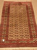 Persian Bokhara red and beige ground rug,
