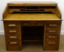Early 20th century oak twin pedestal tambour roll top desk enclosing fitted interior,