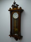 Late 19th century Vienna style walnut wall clock with carved pediment over a glazed door flanked by