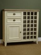 Painted solid pine cupboard, moulded top, two drawers above single cupboard door next to wine rack,