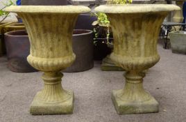 Pair of composite stone Campana shaped urns, reed and gardroon moulded bodies,