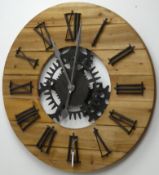 Large circular planked pine wall clock with Roman numerals, skeleton simulated workings