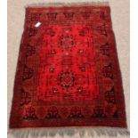 Afghan style red ground rug, two star motifs to centre,