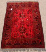 Afghan style red ground rug, two star motifs to centre,