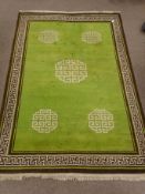 Large oriental brown and green ground rug, geometric pattern field, repeating border,