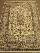 Kashan beige ground rug, central medallion, floral field and repeating border,