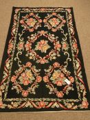 Modern black ground cross stitch rug, floral field and repeating border,