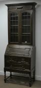 Early 20th century narrow oak bureau bookcase, projecting moulded cornice,