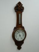 Edwardian carved oak aneroid barometer and thermometer,