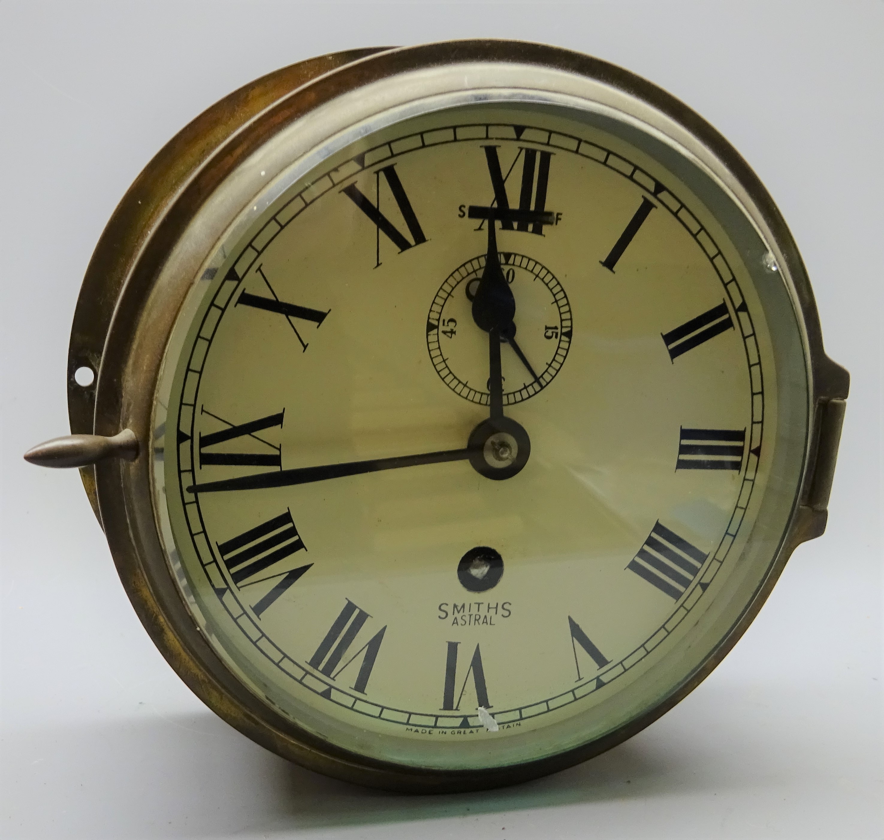 Smiths Astral ship's brass cased bulkhead clock, the white dial with Roman numerals,