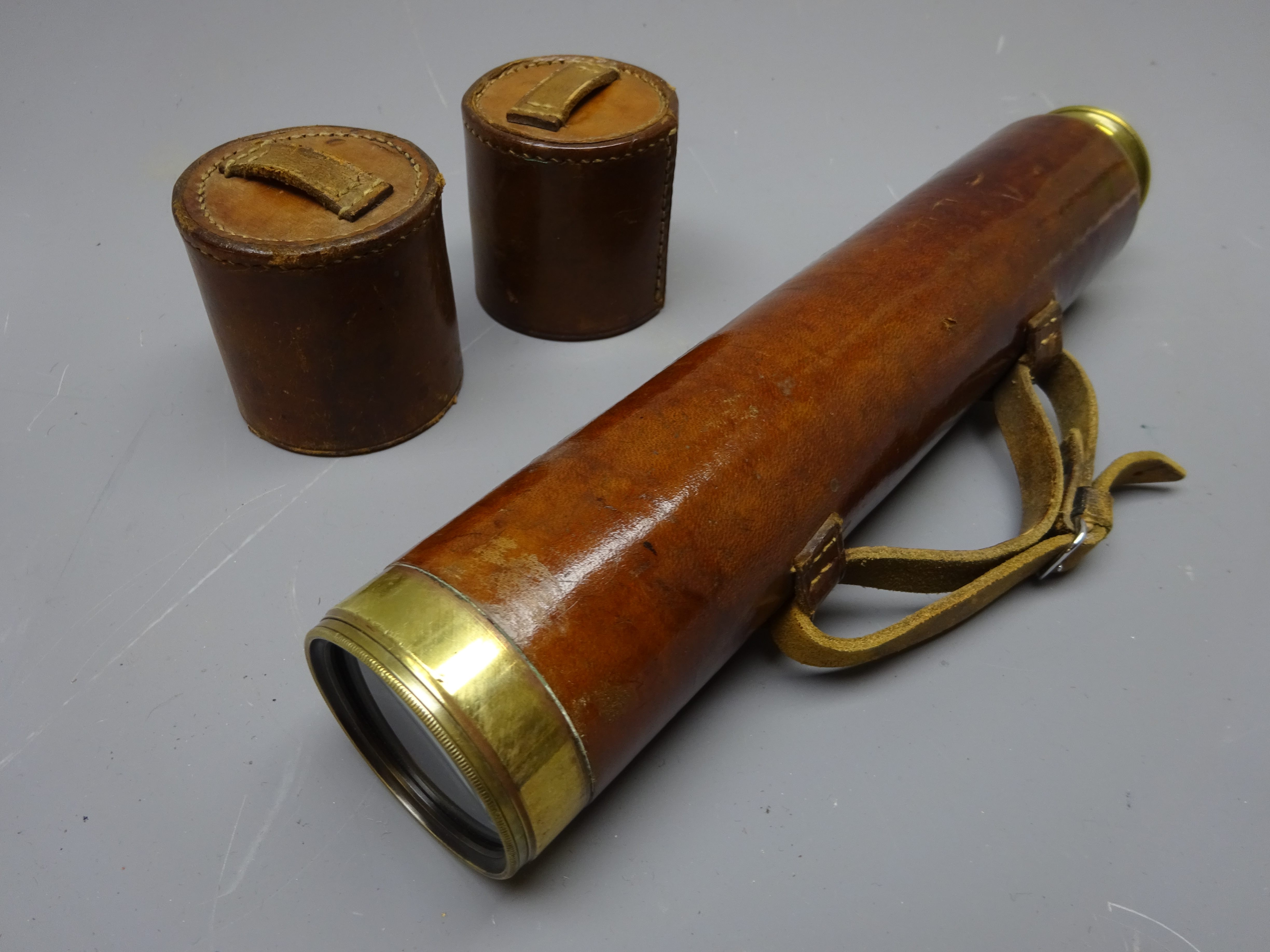 Leather and brass three-draw telescope engraved ' Reconditioned for John Barker & Co.