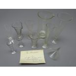 Eight Victorian apothecary's various sized clear glass conical shaped measures with etched