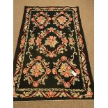 Modern black ground cross stitch rug, floral field and repeating border,