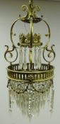 Gilt brass Regency style chandelier cast with floral swags and scroll frame with faceted glass