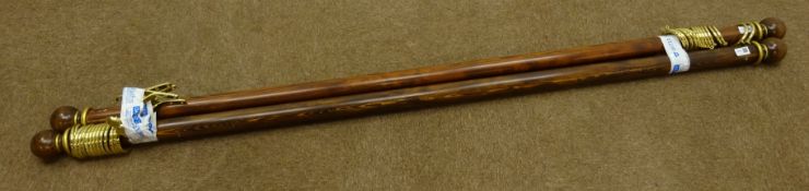 Two medium wood and gilt circular curtain poles with round finials,