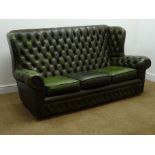 Georgian style wing back sofa upholstered in dark green deeply buttoned leather,