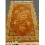 Chinese orange ground rug, central medallion, repeating border,