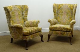 Pair Parker Knoll wingback armchairs, upholstered in a floral fabric, cabriole legs,