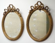 Pair 19th century gilt gesso oval mirrors, reeded frame surmounted by a ribbon tied crest,