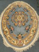 Kayam Chines oval blue ground rug with floral central medallion and repeating border (274cm x