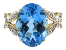 9ct gold blue topaz ring, with diamond set cross over shoulders,