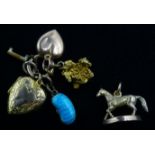 9ct gold horse on plinth, nugget, lockets and kidney bean charms Condition Report 8.