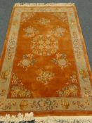 Chinese orange ground rug, central medallion, repeating border,