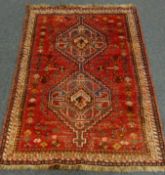 Persian red ground rug, two medallions,