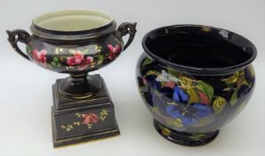 Early 20th century porcelain two handled pedestal urn decorated with roses on black ground H28cm