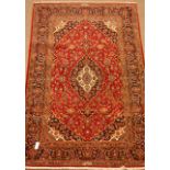 Kashan red ground rug, floral field, repeating border, signed by the weaver,