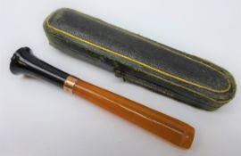 Amber cigarette holder with 9ct gold band, cased L8.