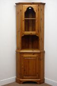 Ducal pine corner cabinet, single arched glazed door with illuminated interior, above cupboard door,