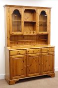 Ducal pine dresser, two glazed doors with central shelves, above three drawers and three cupboards,