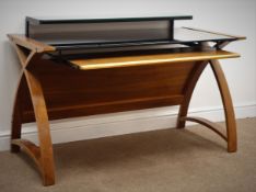 Contemporary walnut finish bent plywood desk with black glass top and keyboard slide, W130cm, H83cm,