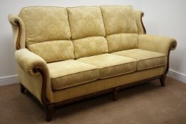 Three seat sofa upholstered in pale gold fabric with mahogany facias (W210cm) and matching two