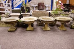 Set of four composite stone circular urn planters, with egg and dart rim on tapered pedestal bases,