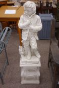 Painted composite stone figure of boy sheltering from the elements, on shaped column base,