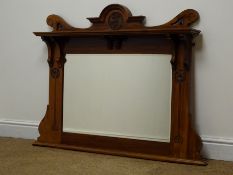 Edwardian Art Nouveau walnut overmantle mirror with top shelf and carved stylised motifs, W105cm,