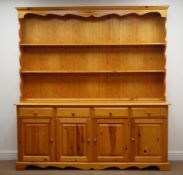Pine farmhouse dresser, two tier plate rack above four drawers and cupboards, shaped plinth base,