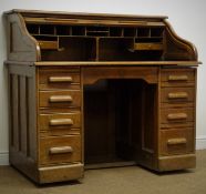 Early 20th century oak tambour roll top desk enclosing fitted interior above one central frieze