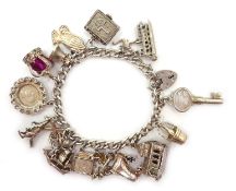 Hallmarked silver curb chain bracelet with padlock and various silver charms Condition
