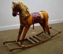 Late 20th century red and gold rocking horse, with bridle, saddle and stirrups,