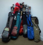 A quantity of golf woods, irons and putters, with six bags, three umbrellas,
