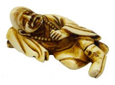 Japanese Meiji ivory Okimono modelled as a man laid, resting his head on a pillow,