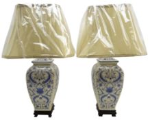 Pair Oriental style blue and white table lamps on ebonised base with shades,