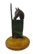 Patinated bronze study of a Horse in stable mounted on oval oak plinth,