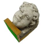 Carved stone corbel carved with a female head, mounted on oak stand, D29cm,