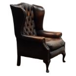 George lll style wingback armchair, upholstered in deep buttoned brown leather, on cabriole legs,