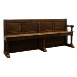 Large 19th century oak church pew, with four panel back, plank seat with end arm rest,