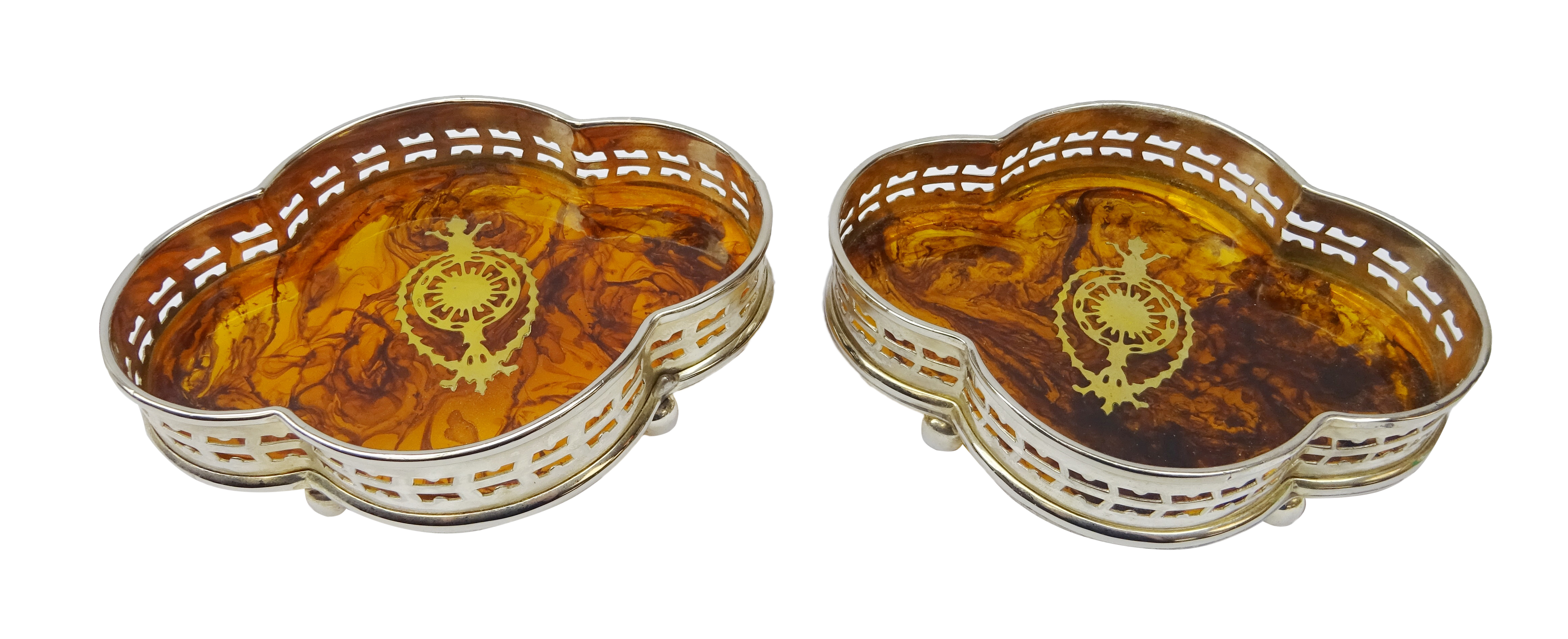 Pair quatrefoil simulated tortoise shell bottle coasters with silver-plate gallery and brass inlay,